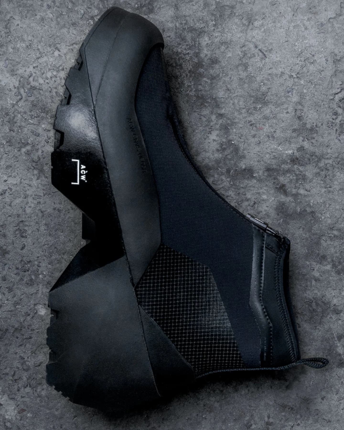 Pair of black A-COLD-WALL x Converse Geo Forma boots on concrete