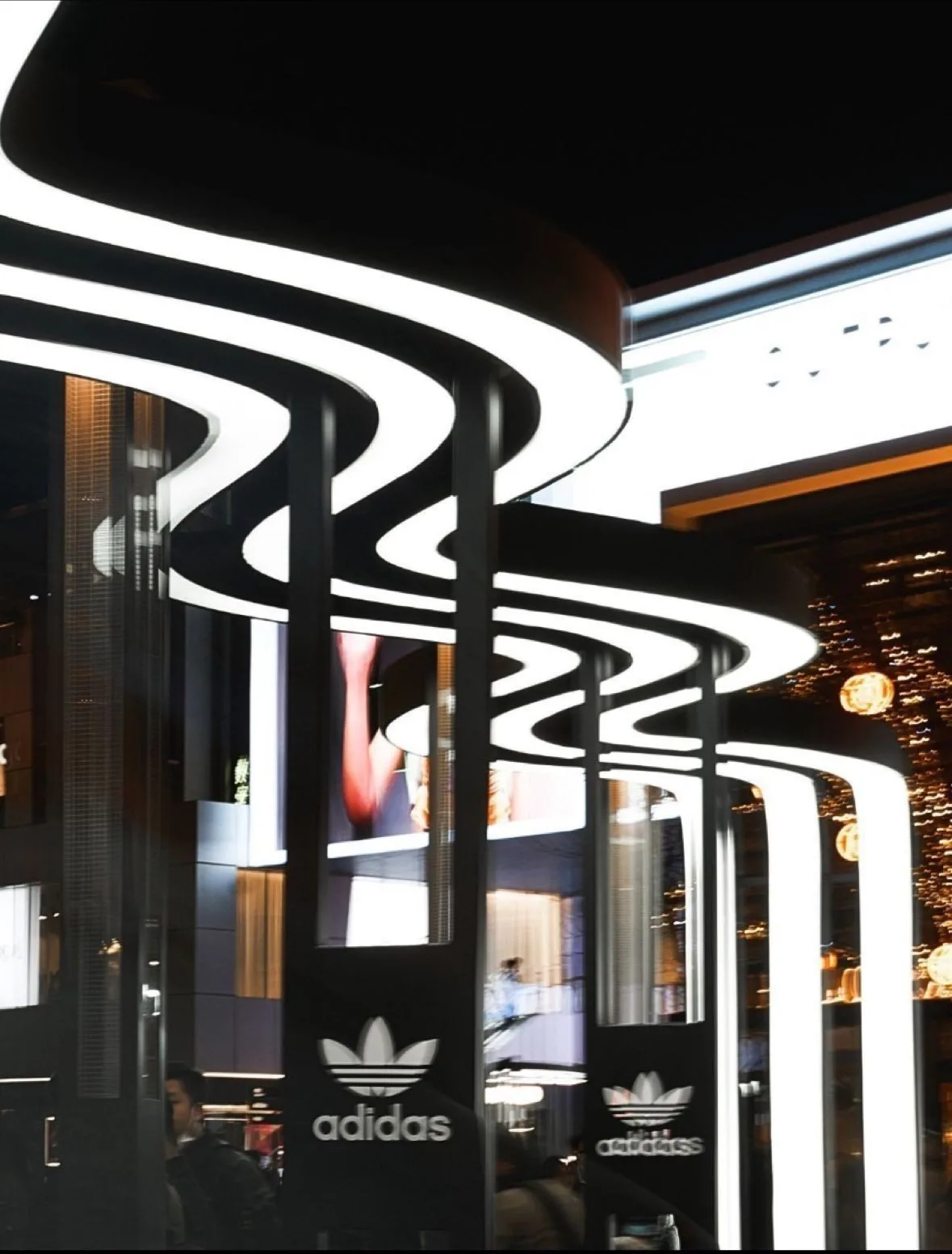 Illuminated black-and-white Three Stripes archways inside the Adidas Beijing activation
