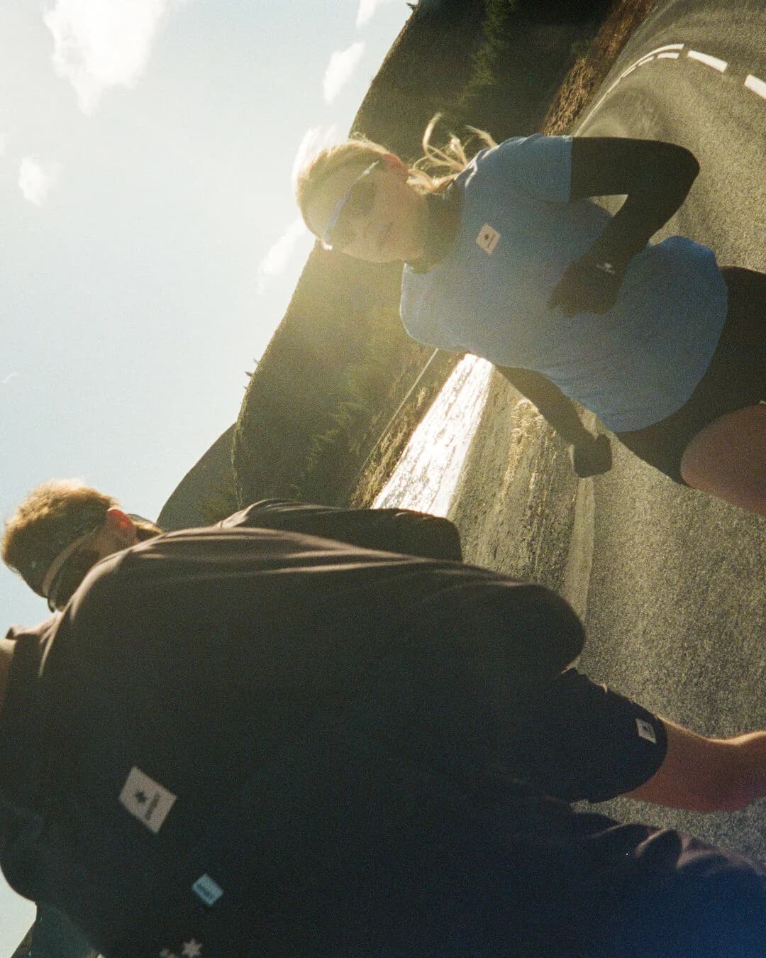 Two runners wearing SAYSKY layers on a sunlit road