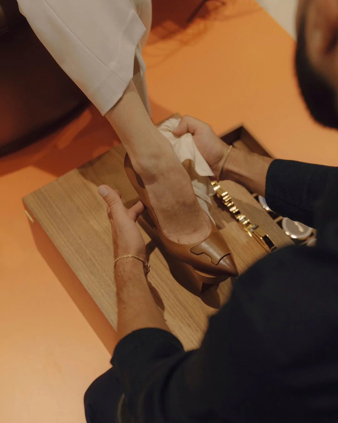 Santoni shoeshine service polishing a brown leather pump