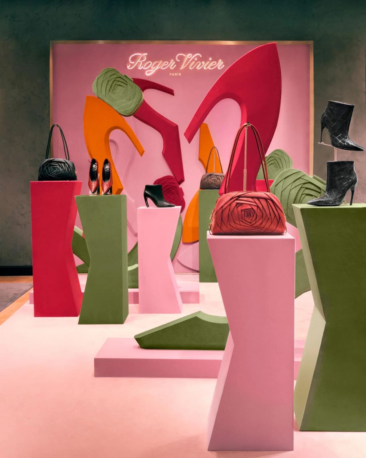 Roger Vivier Choc shoes and Roseling bags arranged on colorful pedestals at Le Bon Marché