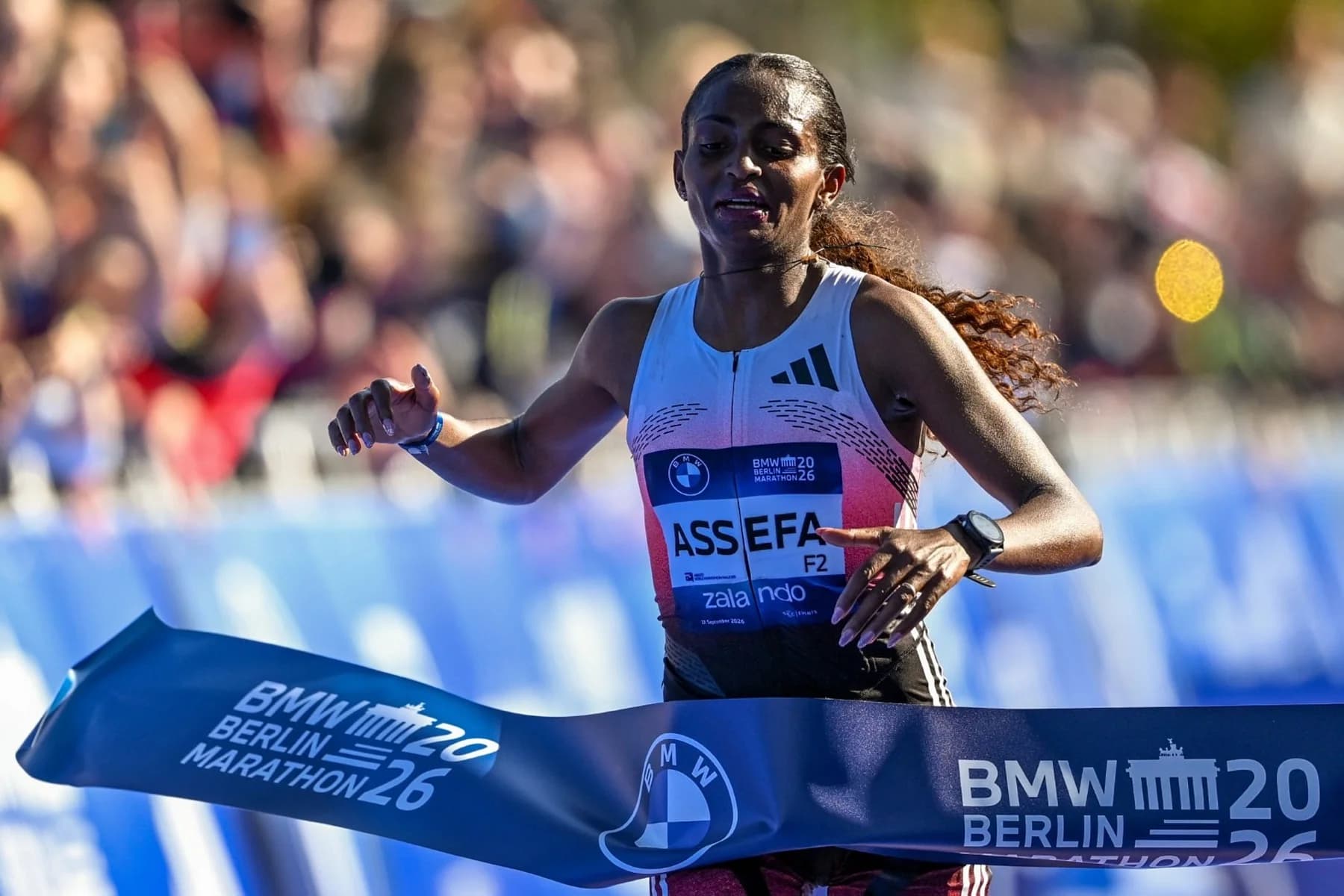 Tigst Assefa crossing the finish line at the 2026 BMW Berlin Marathon