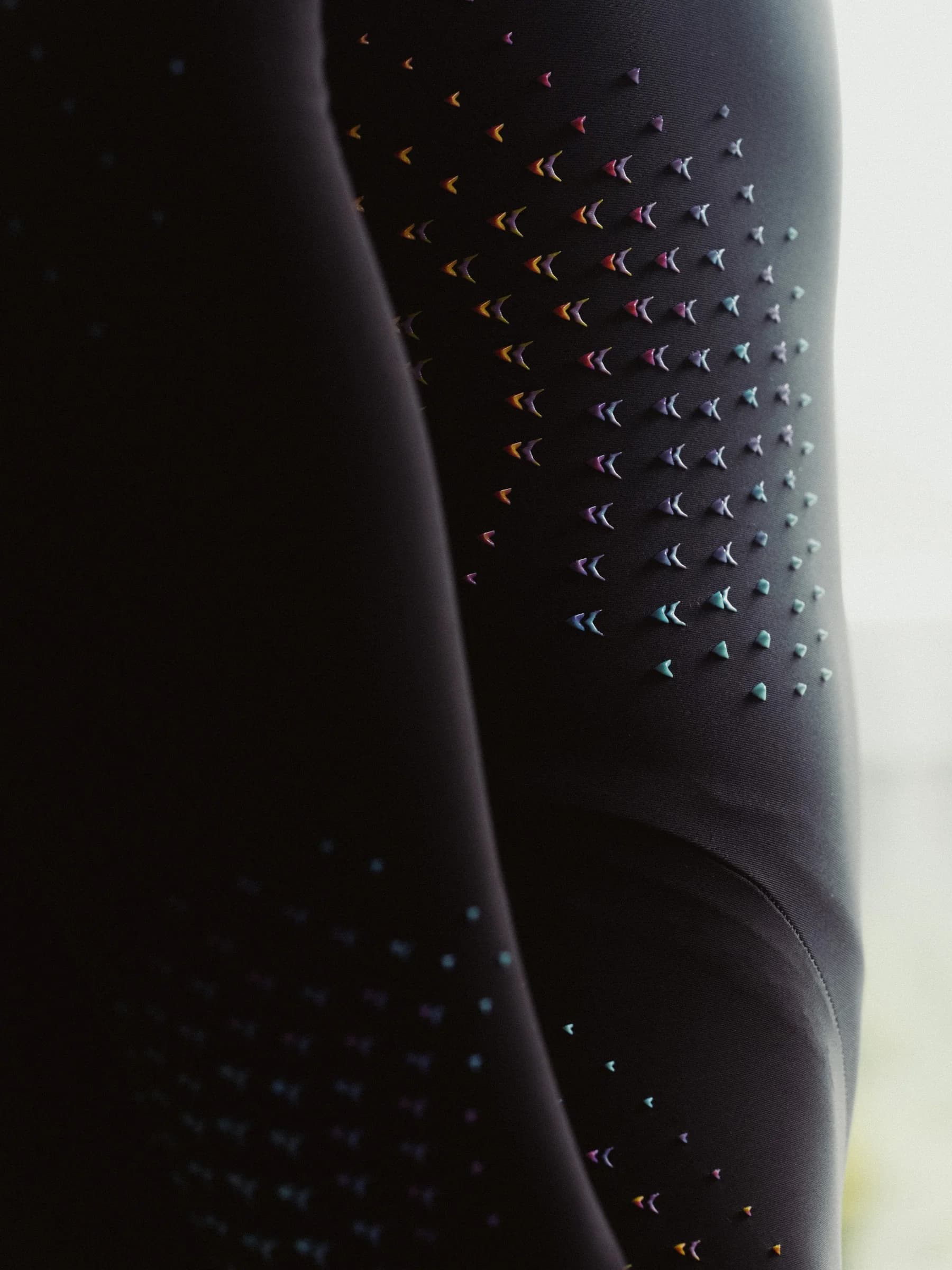 Close view of color shifting aerodynamic devices on Nike speed suit fabric
