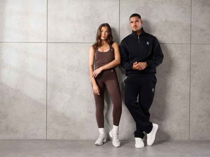 Gym King models in coordinated athleisure looks against a concrete wall