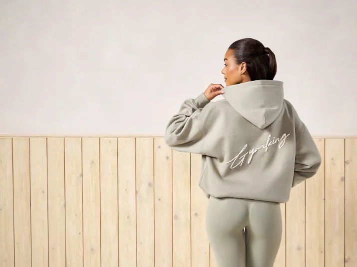 Model wearing a sage Gym King hoodie and matching leggings