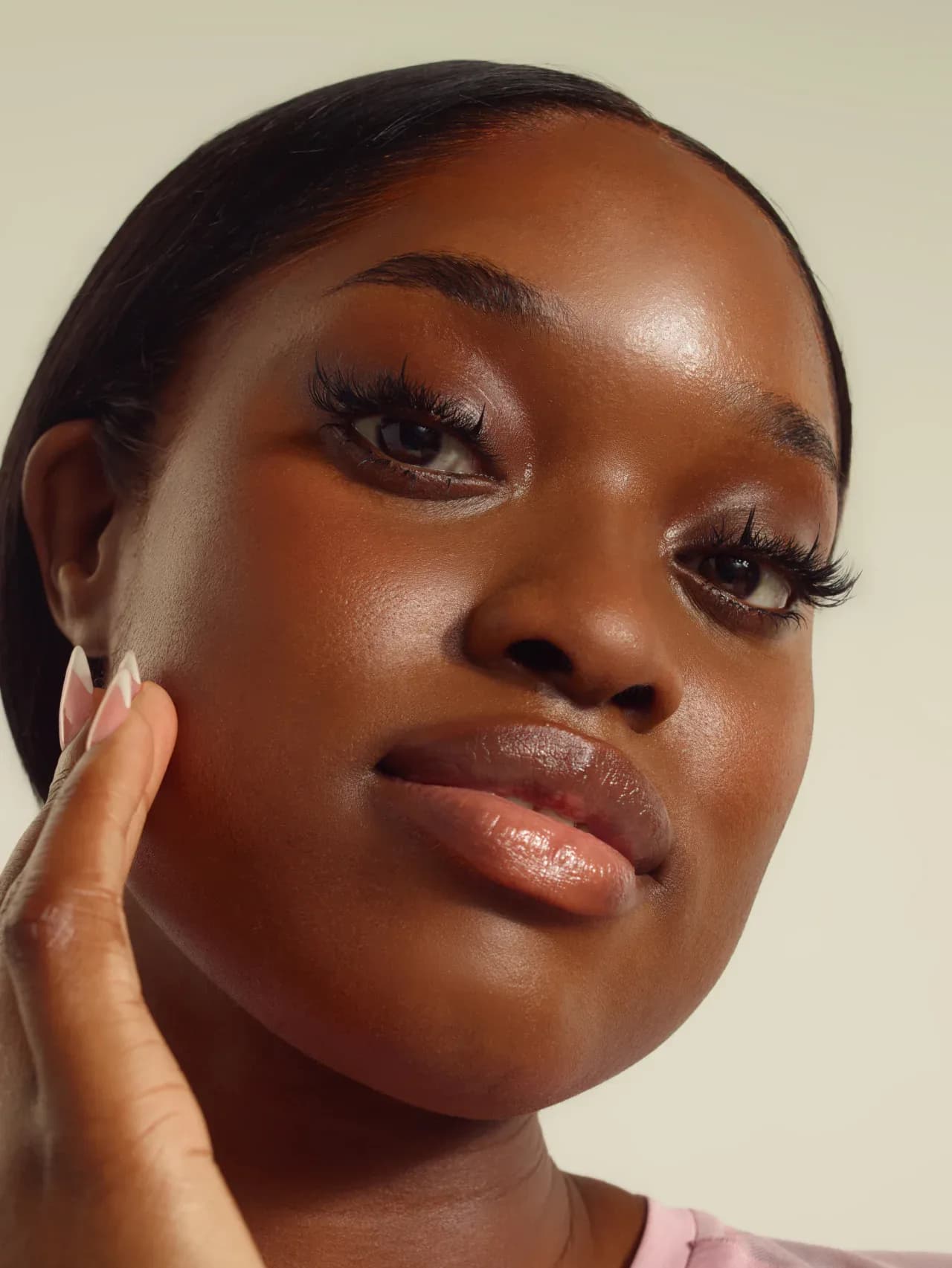 Close-up portrait of a model touching her cheek in the ASICS Get The Glow campaign