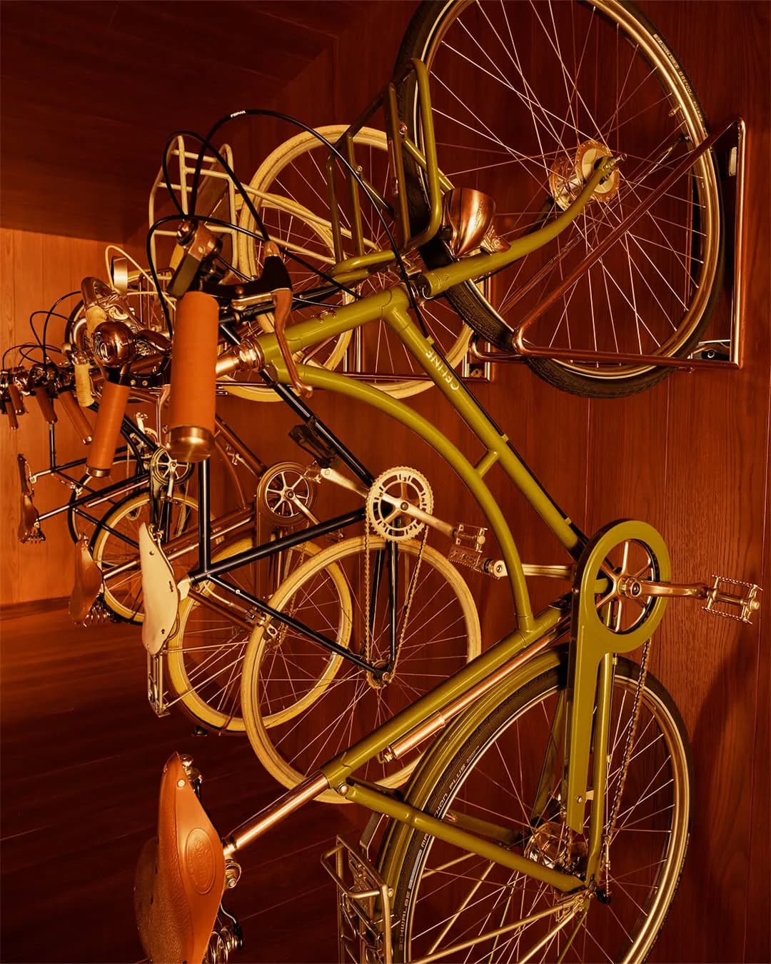 Vintage-style CELINE bicycles mounted on a wood-paneled wall