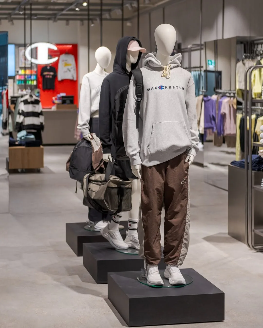 Mannequins wearing Champion Manchester hoodies and track pants inside the flagship
