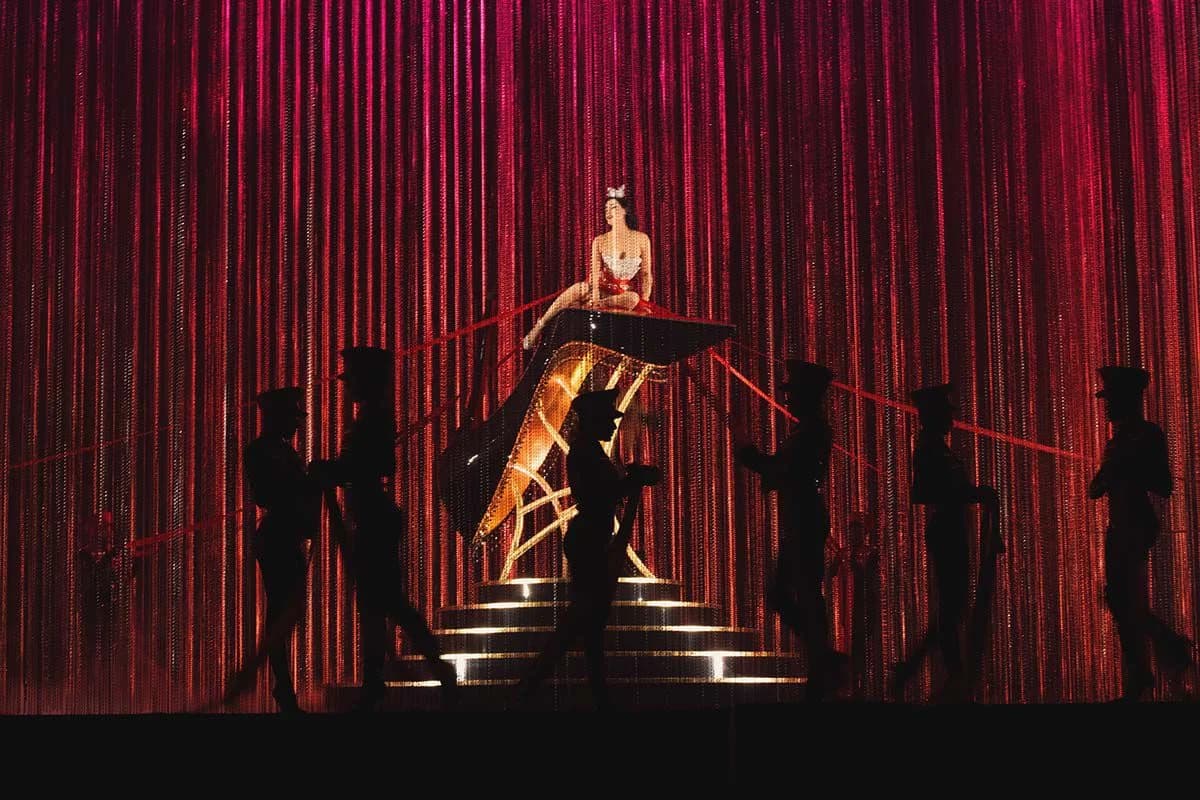 Dita Von Teese above the red-lit Eternal Youth stage for Christian Louboutin Spring/Summer 2027
