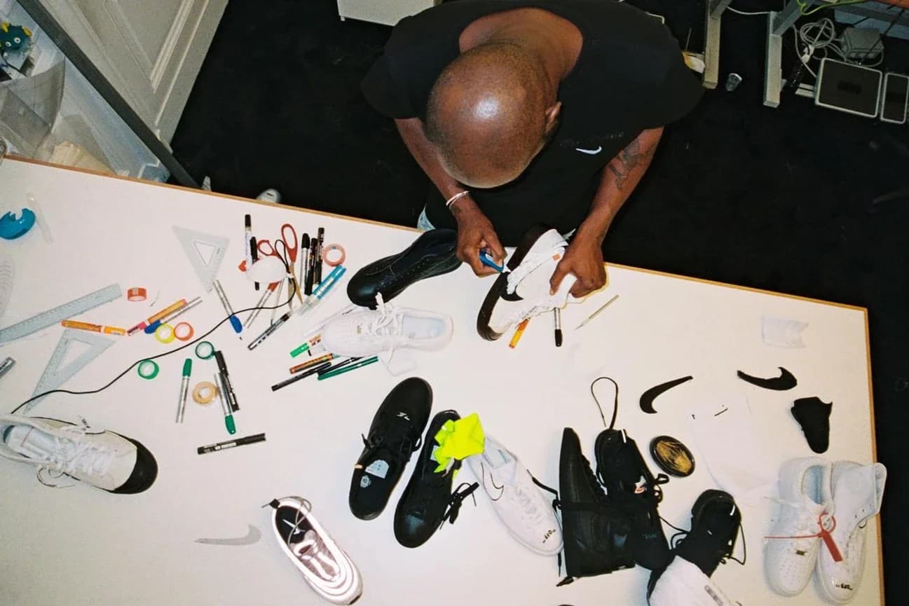 Virgil Abloh works on Nike footwear designs at a table.