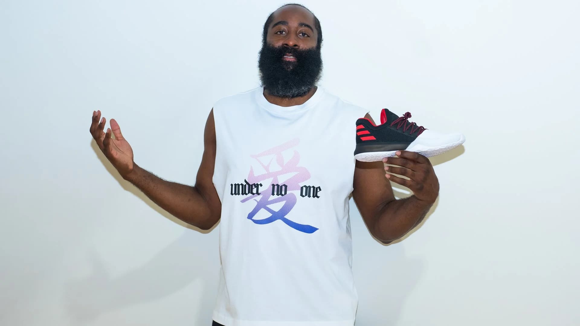 James Harden holds the black, red and white adidas Harden Vol. 1 Pioneer.