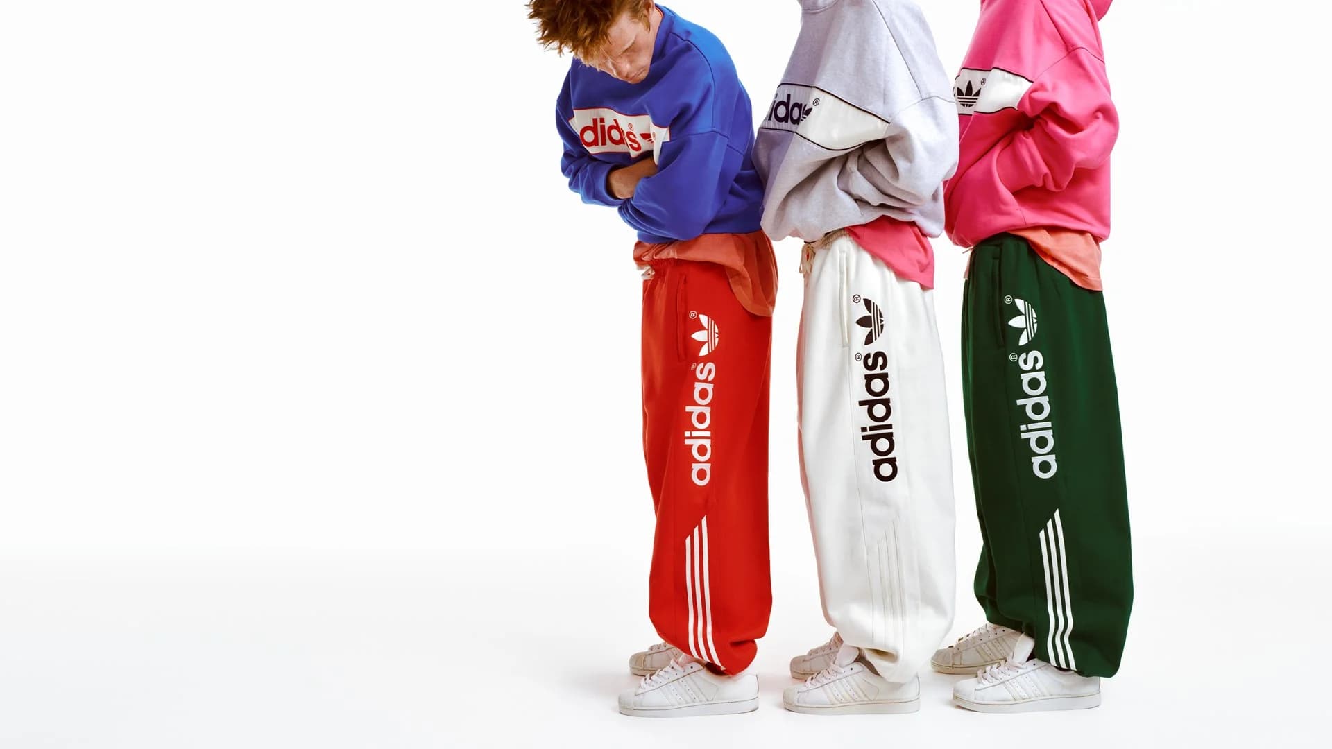 Three models in vivid blue, grey and pink adidas sweat sets from the adiSignature campaign.