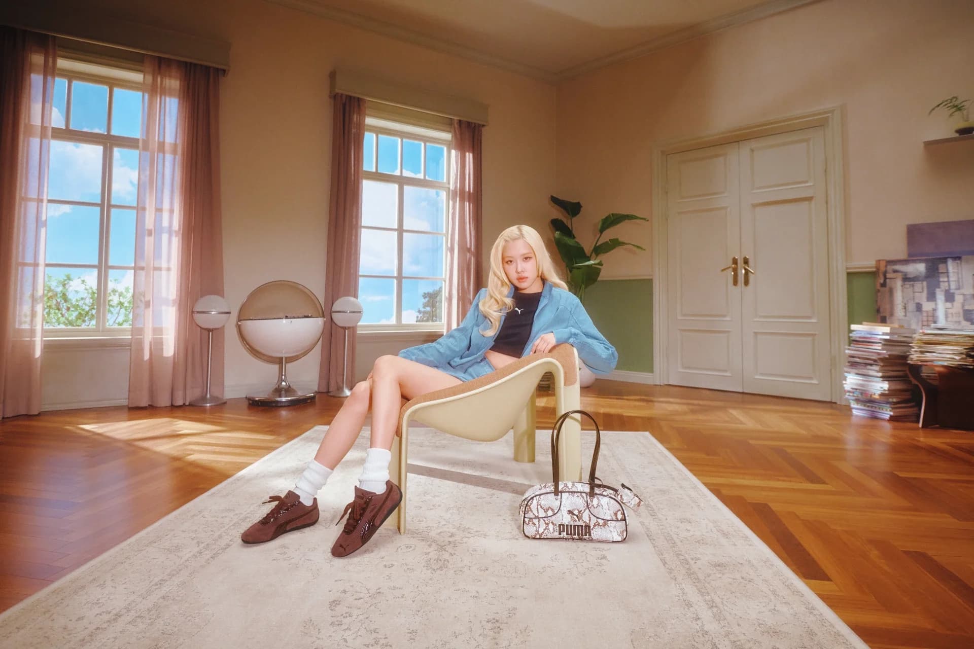 Rosé wearing brown PUMA Speedcat shoes in a softly lit room