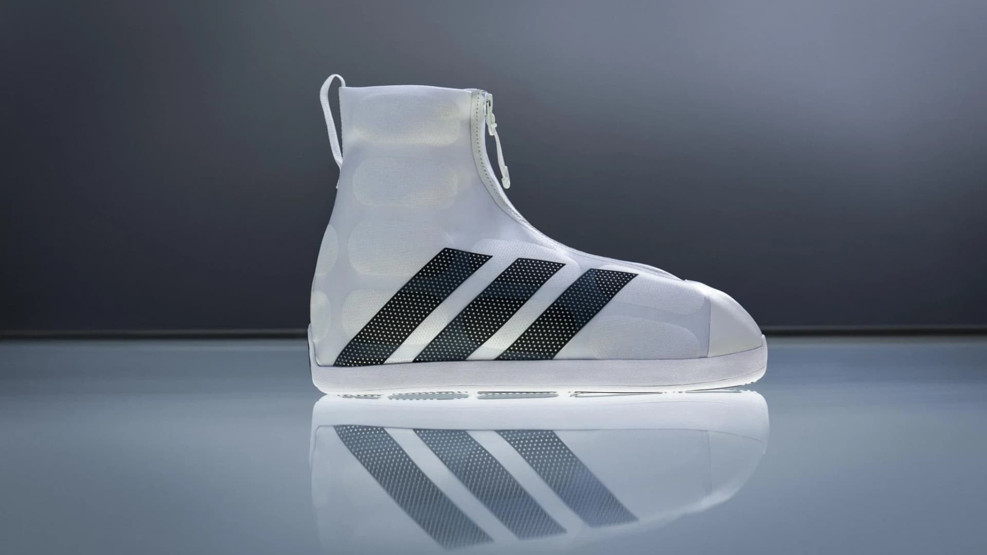 White high-top adidas footwear with black three stripes photographed on a reflective surface