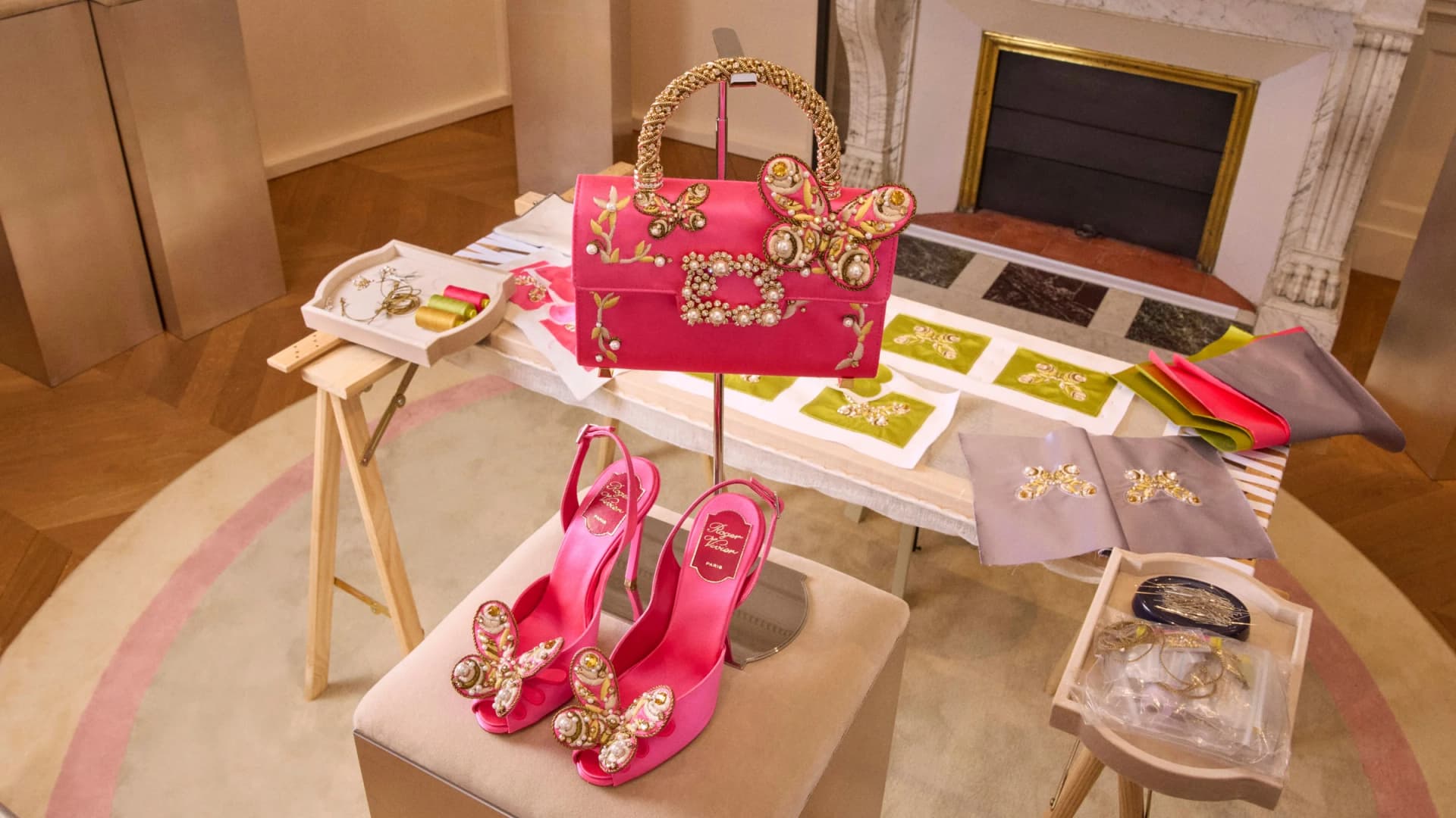 Pink butterfly-embellished Roger Vivier slingback heels displayed with a matching handbag at the Vivier en Fleur presentation