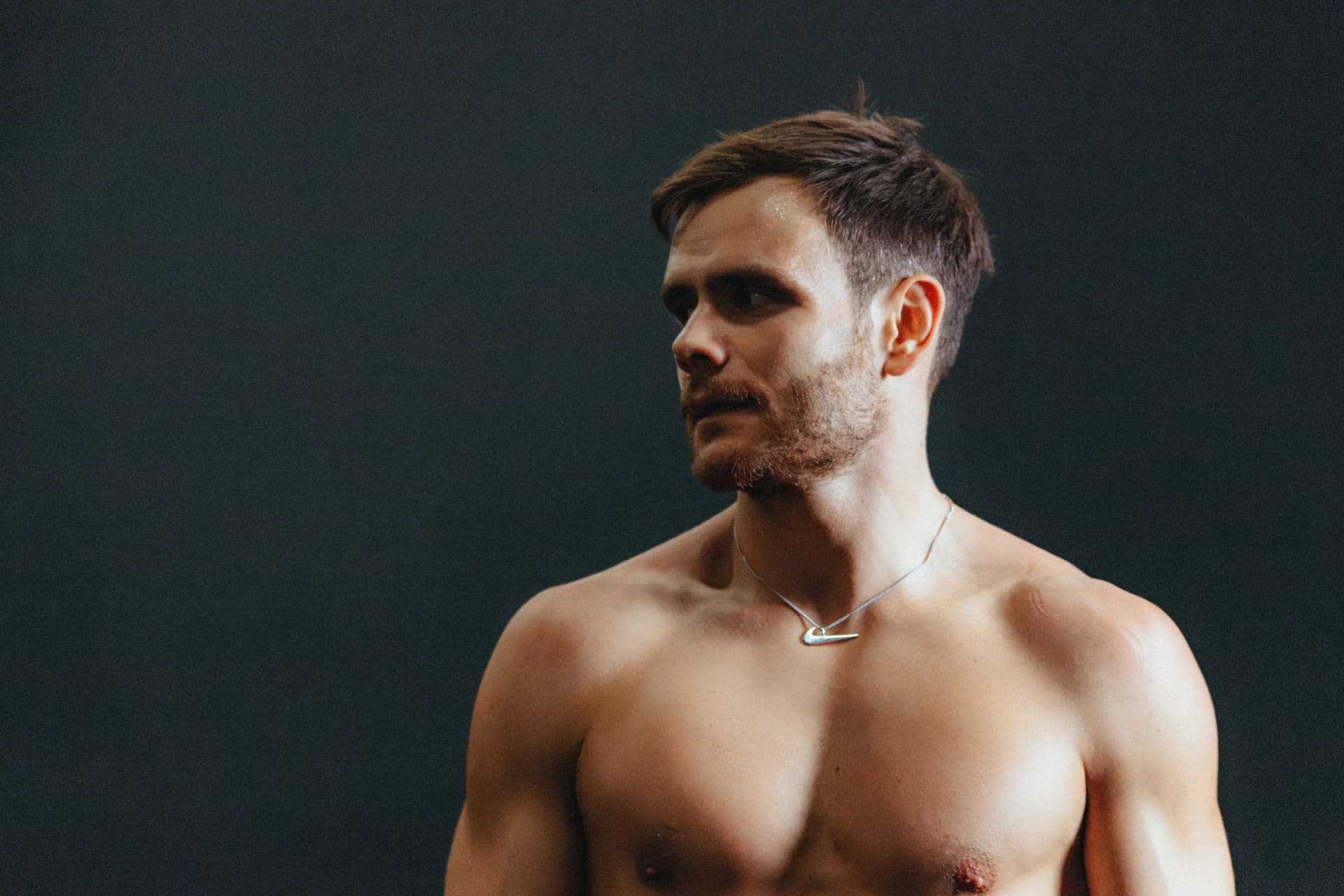 Tim Wenisch wearing a Nike pendant against a dark background