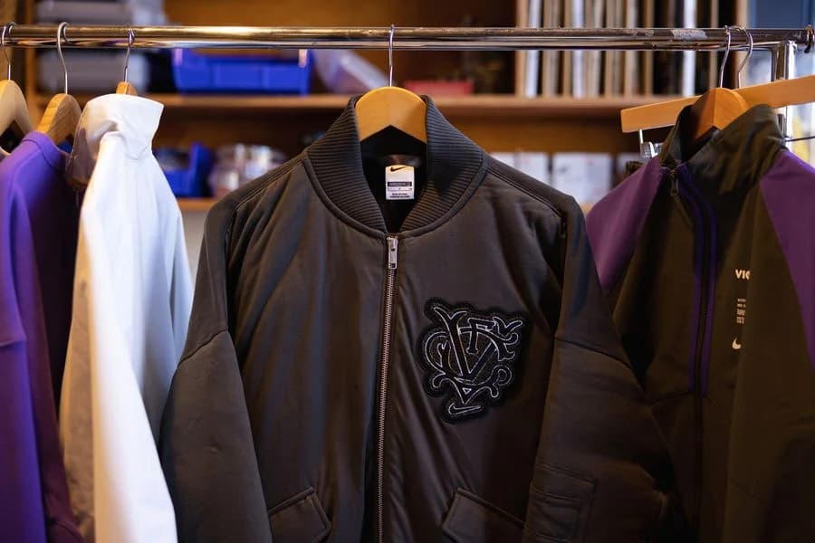 A black Nike Victory FC bomber jacket hangs among pieces from the Megan Rapinoe apparel collection