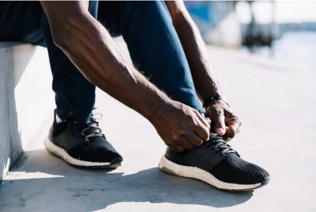 Man tying his left shoelaces