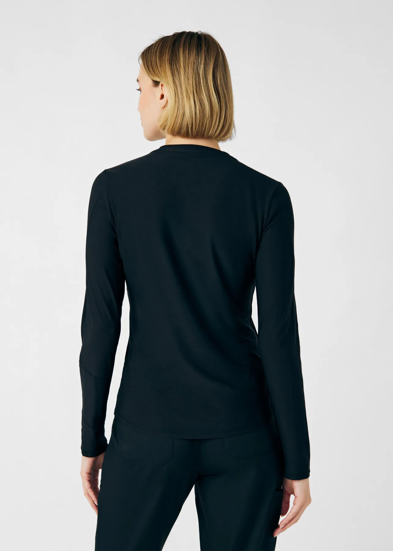 Rear view of a black Kindthread long-sleeve scrub top and pants
