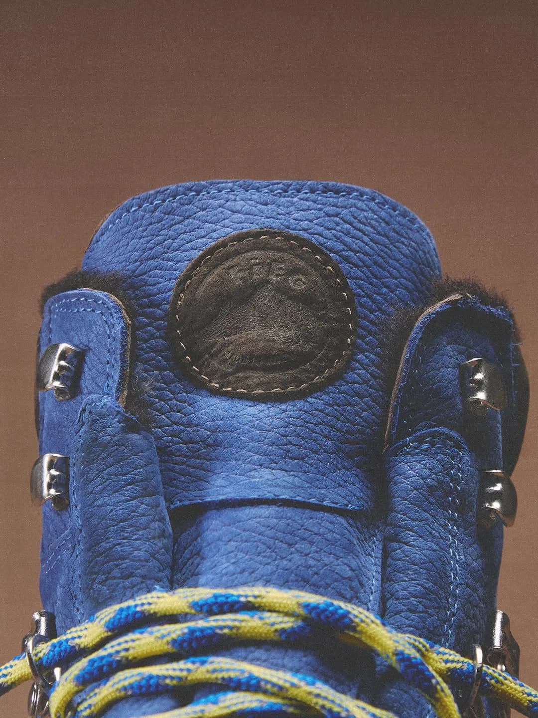 Close-up of a blue Kith x Diemme boot tongue, logo patch, and laces