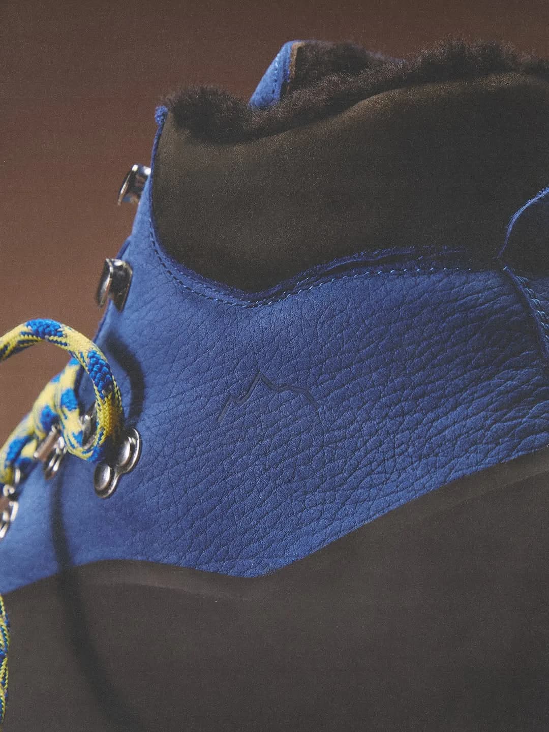 Close-up of a blue leather Kith x Diemme boot collar and metal eyelets