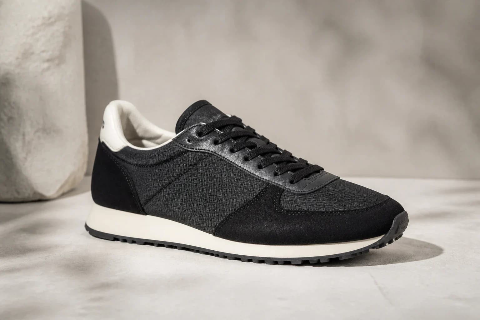 Unbranded low black nylon and suede archival-style runner on a pale stone set