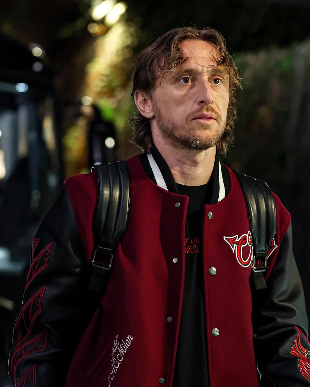 AC Milan player with a backpack wearing the red-and-black Off-White varsity jacket