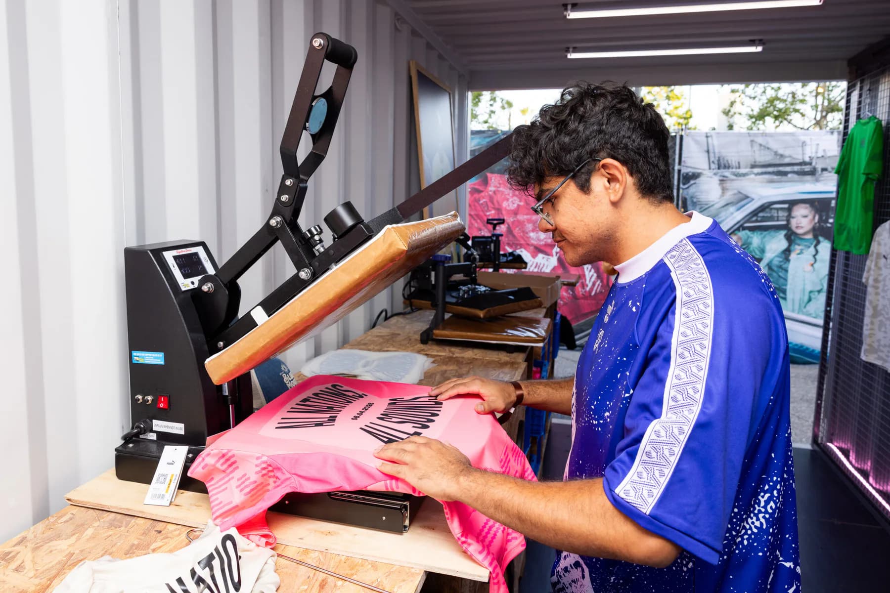 Staff member heat-pressing a pink PUMA football jersey at the activation