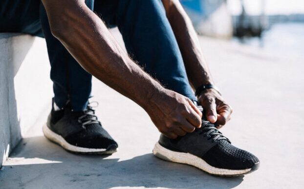 Man tying his left shoelaces