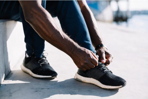 Man tying his left shoelaces
